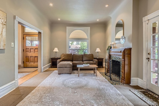 living room featuring plenty of natural light, a fireplace with flush hearth, carpet flooring, recessed lighting, and baseboards