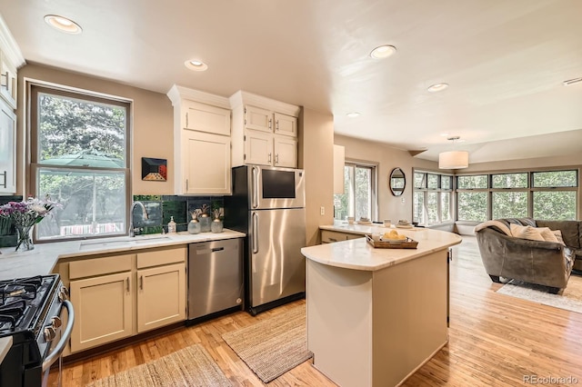 kitchen featuring appliances with stainless steel finishes, healthy amount of natural light, a sink, open floor plan, and recessed lighting
