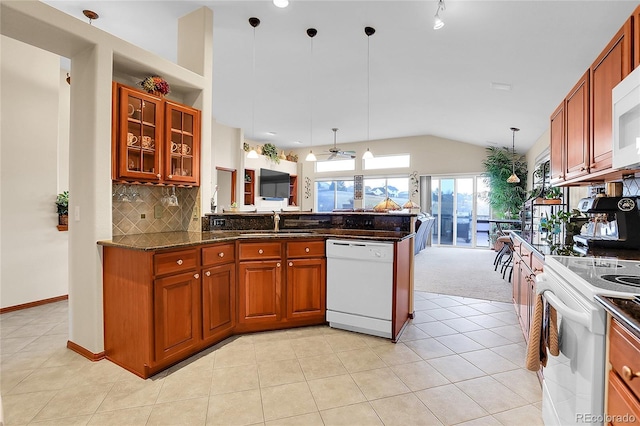 kitchen with white appliances, decorative light fixtures, a sink, vaulted ceiling, and backsplash