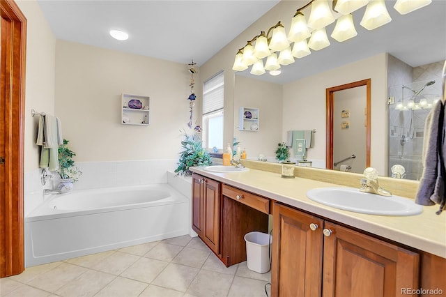 bathroom with double vanity, tile patterned flooring, a sink, and a bath