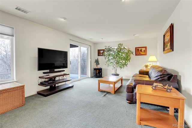 carpeted living room featuring plenty of natural light, visible vents, and baseboards