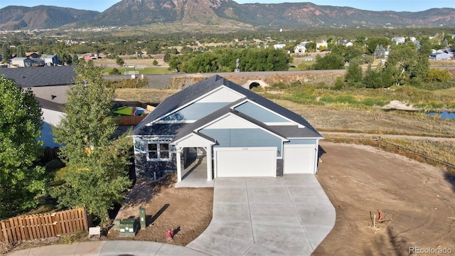 view of front of home featuring driveway, fence, and a mountain view