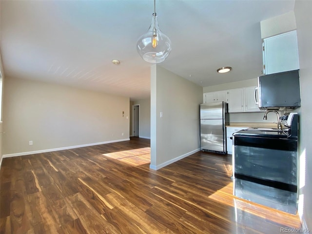 1243 Gaylord St Unit 302, Denver, CO 80206 - kitchen featuring freestanding refrigerator, dark wood-style flooring, range, white cabinets, and decorative light fixtures