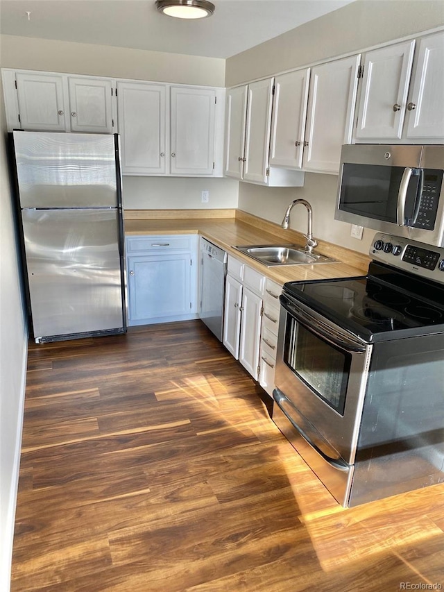 1243 Gaylord St Unit 302, Denver, CO 80206 - kitchen with appliances with stainless steel finishes, dark wood finished floors, light countertops, and white cabinetry