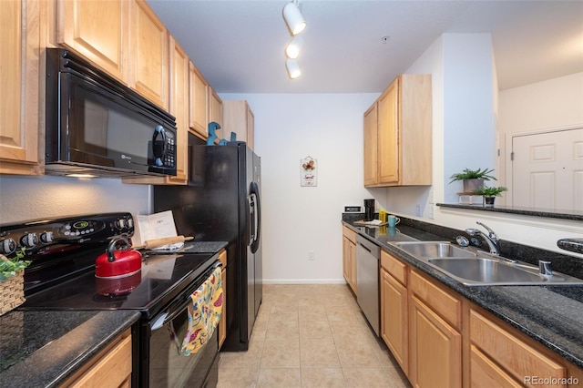 kitchen with light tile patterned flooring, a sink, black appliances, dark stone countertops, and baseboards