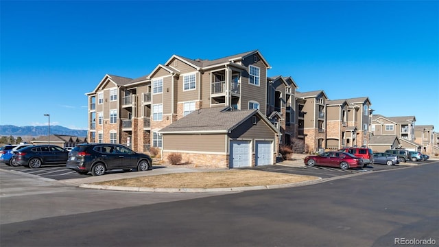 view of front of home featuring a mountain view, uncovered parking, and a residential view