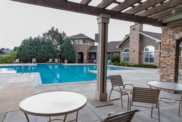 community pool with a patio and a pergola