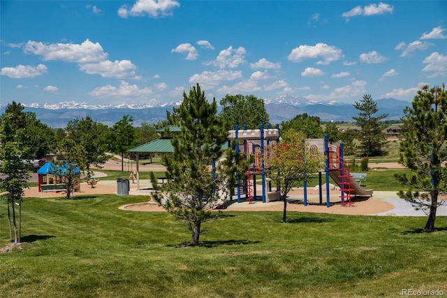 community playground with a mountain view and a yard