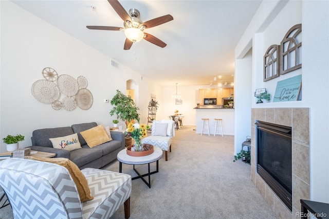 3100 Blue Sky Cir Unit 205, Erie, CO 80516 - living room featuring light colored carpet, a fireplace, a ceiling fan, and arched walkways