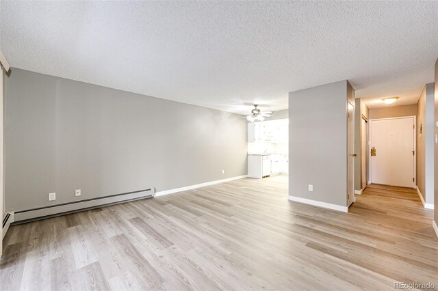 unfurnished living room featuring ceiling fan, light wood-type flooring, a textured ceiling, and a baseboard heating unit