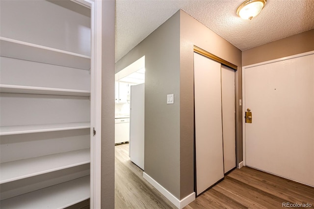 hallway featuring hardwood / wood-style floors and a textured ceiling