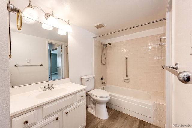 full bathroom featuring wood-type flooring, washtub / shower combination, vanity, and toilet