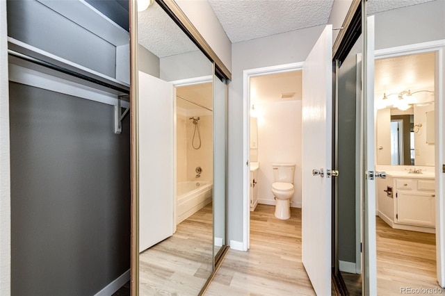 full bathroom with hardwood / wood-style flooring, a textured ceiling, toilet, and vanity