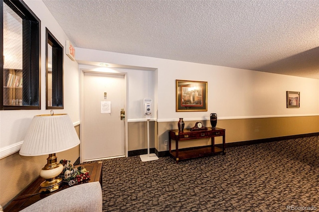 hallway featuring a textured ceiling and carpet