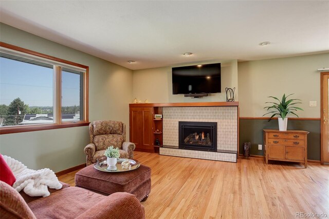 living room with light hardwood / wood-style floors and a tile fireplace