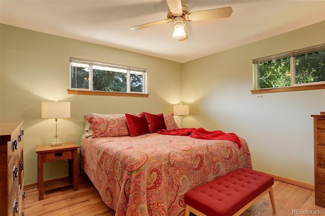 bedroom featuring multiple windows, ceiling fan, and light wood-type flooring