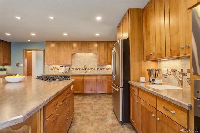 kitchen with appliances with stainless steel finishes, sink, and backsplash