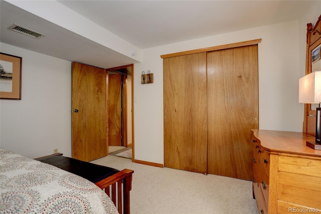 bedroom featuring light colored carpet and a closet