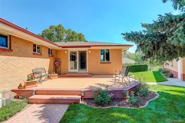 rear view of property with a lawn and a deck