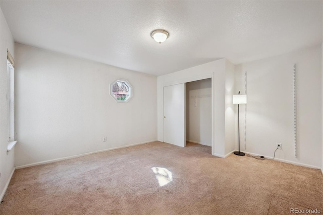 unfurnished bedroom with carpet, a closet, and baseboards