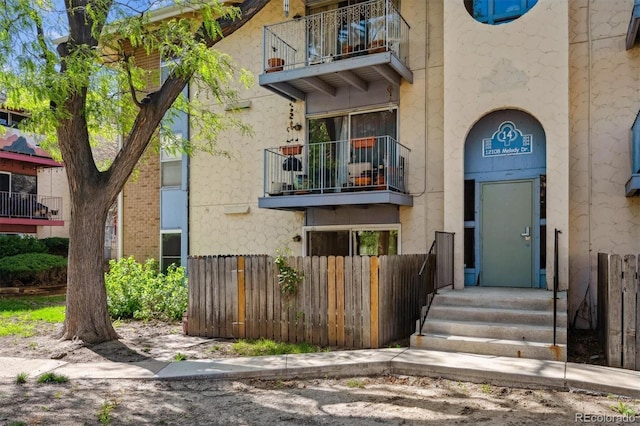 doorway to property with fence and a balcony