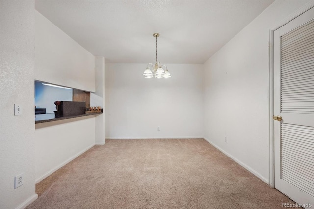 unfurnished dining area featuring carpet, a chandelier, and baseboards