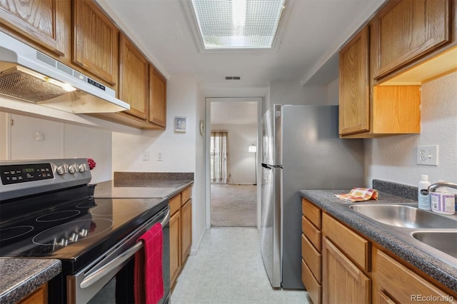 kitchen featuring stainless steel appliances, under cabinet range hood, brown cabinets, and dark countertops