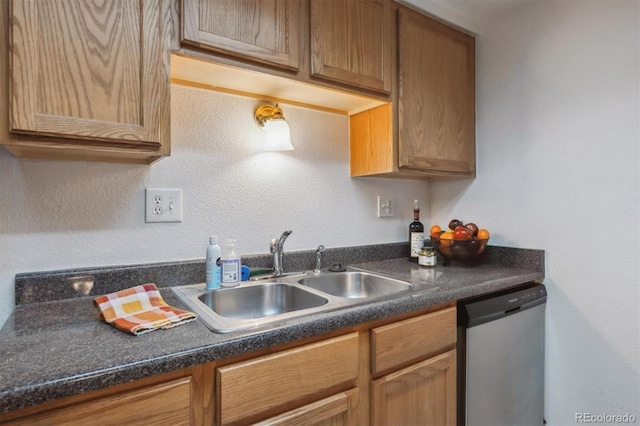 kitchen with dishwasher, a sink, dark countertops, and brown cabinetry