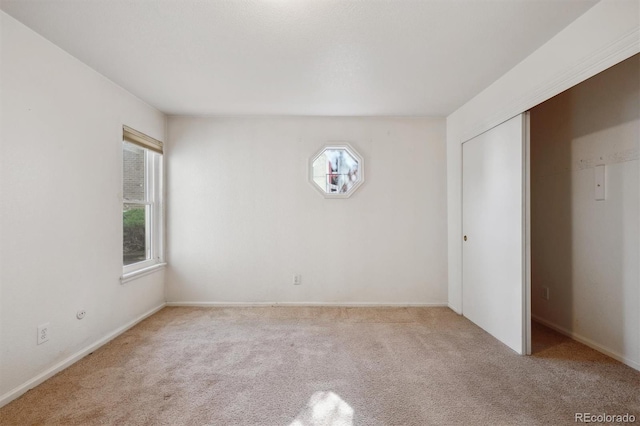 unfurnished bedroom with carpet, a closet, and baseboards