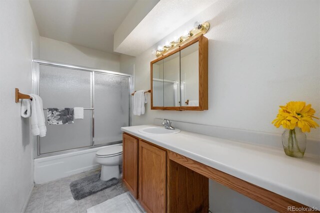 bathroom with vanity, toilet, and bath / shower combo with glass door
