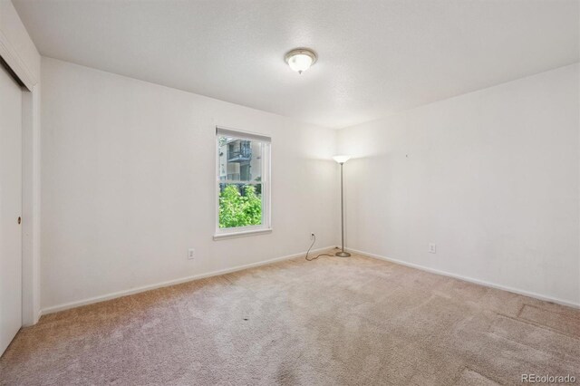 unfurnished bedroom featuring carpet, baseboards, and a closet
