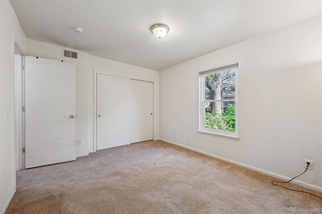unfurnished bedroom featuring carpet floors, a closet, and baseboards