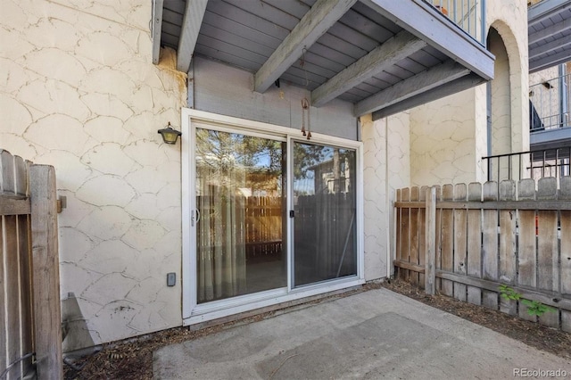 entrance to property featuring a patio and fence