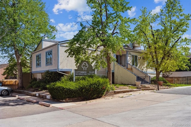 view of front of home with fence and stairway