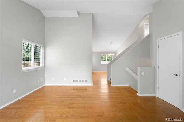 4127 S Lewiston Cir, Aurora, CO 80013 - unfurnished room with healthy amount of natural light, a chandelier, light wood finished floors, baseboards, and high vaulted ceiling