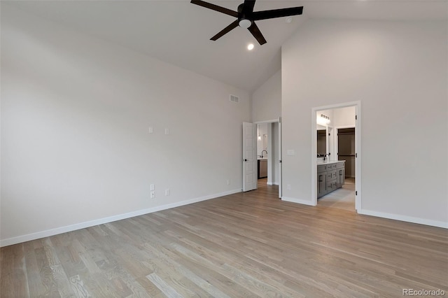 unfurnished bedroom with ensuite bath, high vaulted ceiling, ceiling fan, and light wood-type flooring