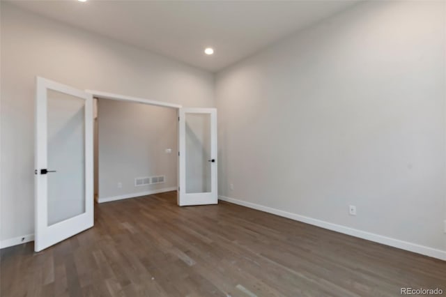 unfurnished bedroom featuring dark wood-type flooring and french doors