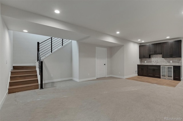 unfurnished living room featuring sink and light carpet