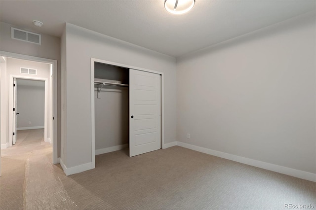 unfurnished bedroom featuring a closet and light carpet