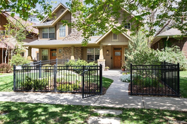 view of front facade featuring stone siding, a gate, and fence