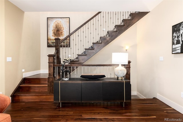 stairs featuring wood finished floors and baseboards