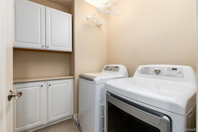 washroom featuring cabinet space and separate washer and dryer