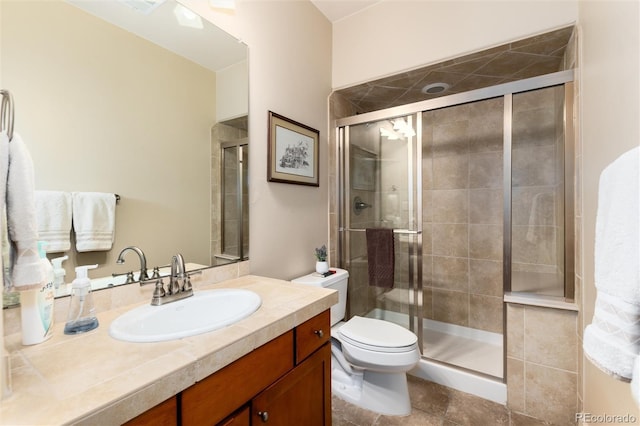 full bath with a stall shower, toilet, and vanity