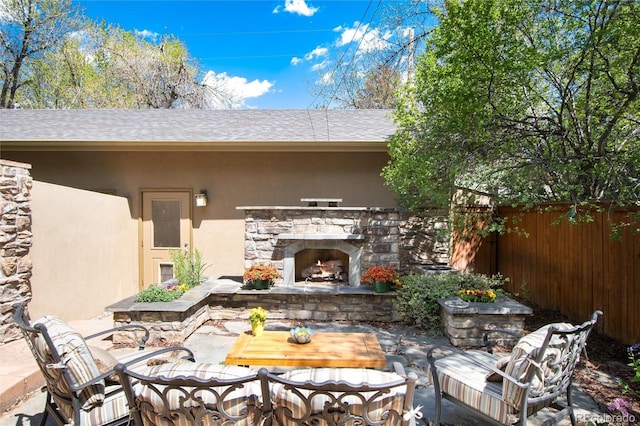 view of patio / terrace featuring fence and an outdoor living space with a fireplace