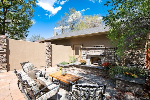 view of patio / terrace featuring an outdoor stone fireplace