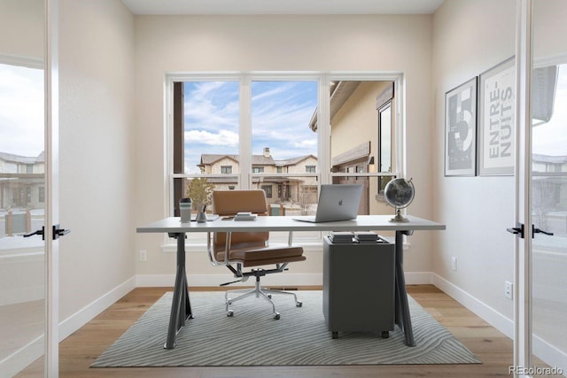 home office with light hardwood / wood-style floors