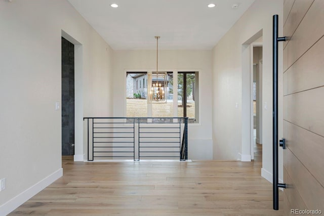 unfurnished dining area featuring light hardwood / wood-style floors and an inviting chandelier