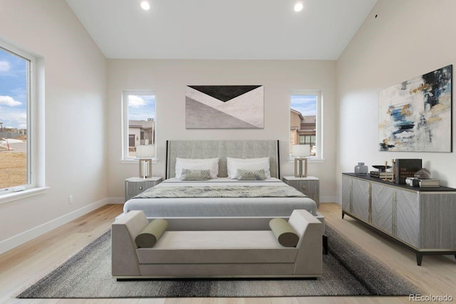 bedroom with light hardwood / wood-style floors, lofted ceiling, and multiple windows