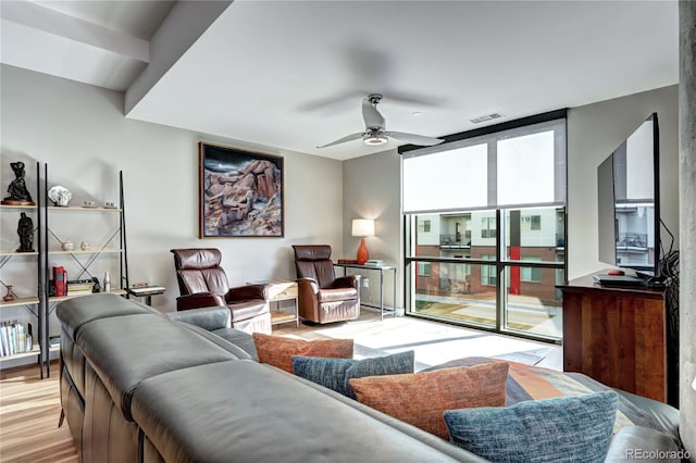 living room with ceiling fan and light hardwood / wood-style flooring