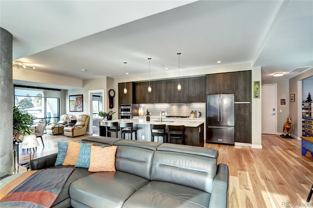 living room with light hardwood / wood-style floors and sink